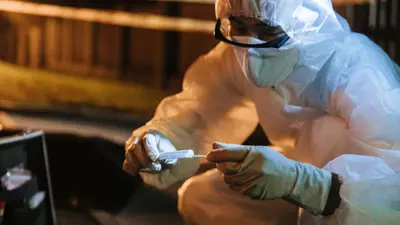 Person wearing protective suit examining something