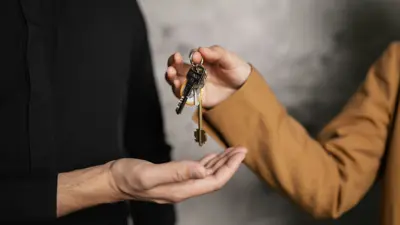 Person handing over keys to another person