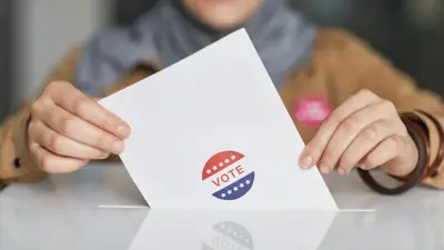 Person putting paper in ballot box