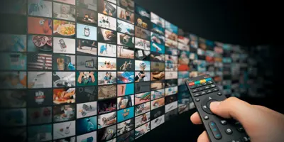 Wall of channels with someone holding a remote