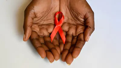 Hands holding a red bow symbol