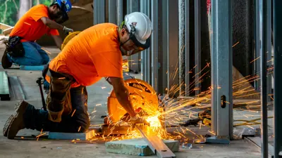 Person with saw working on a building